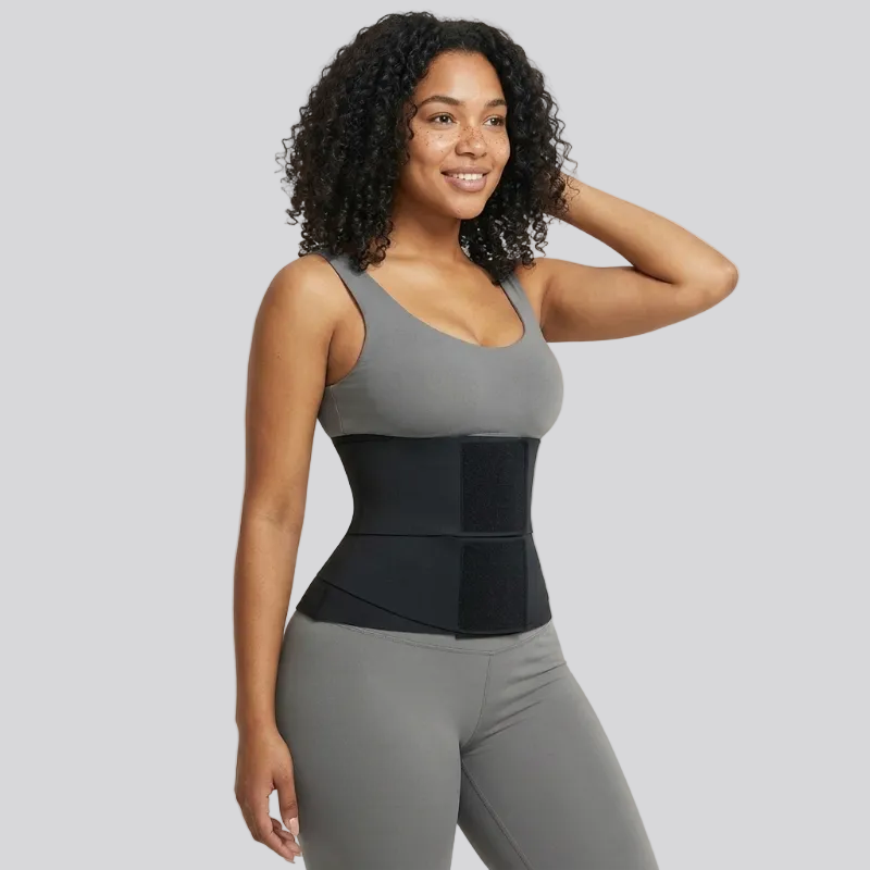 Woman wearing a gray tank top and black waist trainer against a beige background